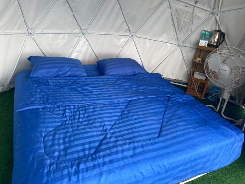 Ban Non Na Yaoกังหันลมแคมป์ปิ้ง的帐篷内的蓝色床和风扇