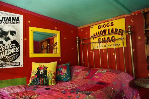伊尔弗勒科姆Surfers and walkers cosy camping cabin的卧室配有一张床和墙上的海报
