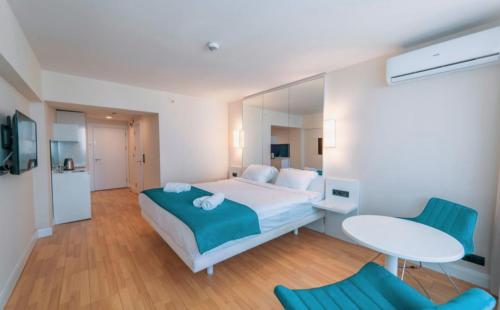 巴统Batumi Next Sea Aparthotel的卧室配有一张床和一张桌子及椅子