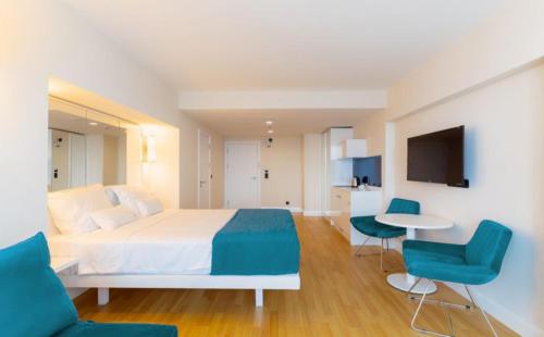 巴统Batumi Next Sea Aparthotel的卧室配有白色的床和蓝色的椅子