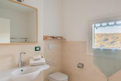 巴哈撒丁岛伊亚比安卡公寓酒店的一间带水槽和卫生间的浴室以及窗户。