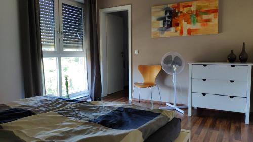 卡尔卡尔Ferienhaus-Kalkar的一间卧室配有一张床、梳妆台和椅子