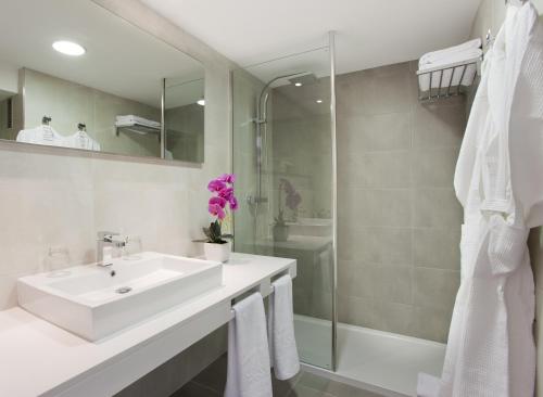 Cala MendiaInsotel Cala Mandia Resort的白色的浴室设有水槽和淋浴。