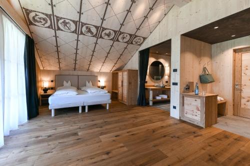 阿尔卑斯休斯山Dolomites Living Hotel Tirler的一间卧室设有一张床和格子天花板