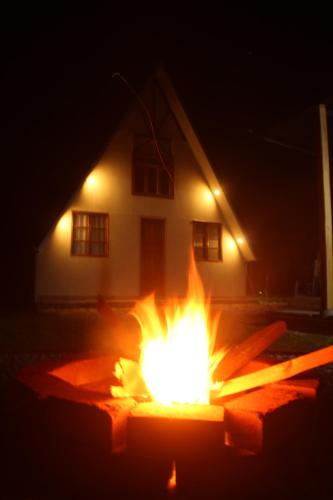 奥克萨潘帕Cabaña Alpina SEAL的夜晚在房子前面的火坑