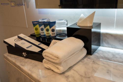 吉达Romera Hotel的浴室的台面上堆着毛巾