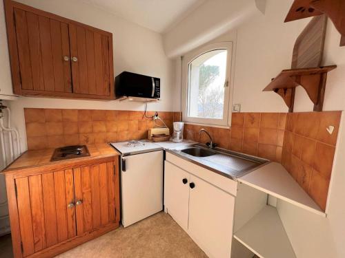 康博莱班Appartement Cambo-les-Bains, 1 pièce, 2 personnes - FR-1-495-31的一个带木制橱柜和水槽的小厨房