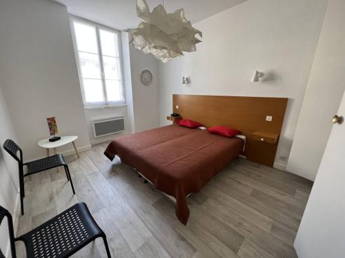 康博莱班Appartement Cambo-les-Bains, 2 pièces, 3 personnes - FR-1-495-79的一间卧室配有一张床、一张桌子和一个吊灯。