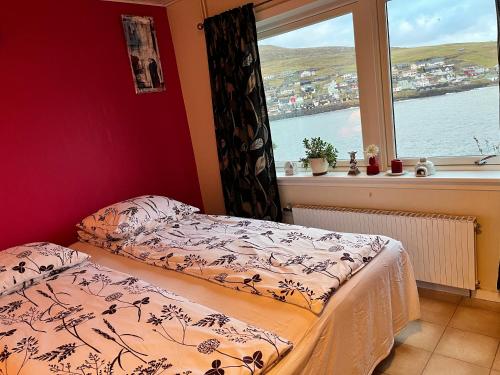 SandavágurThe Atlantic view guest house, Sandavagur, Faroe Islands的一间卧室设有一张床和一个窗口