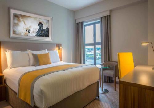 伦敦德里德里玛尔顿酒店的配有一张床、一张书桌和一扇窗户的酒店客房