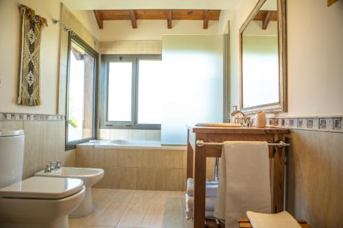 特来凡林Lago Rosario Lodge的浴室配有卫生间、盥洗盆和浴缸。