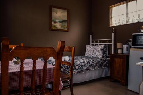 布隆方丹Farm stay at Thyme Cottage on Haldon Estate的卧室配有一张床和一张桌子及椅子