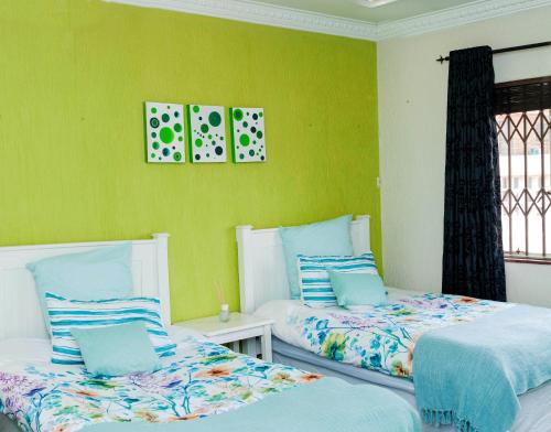LenasiaKINGFISHER PLACE的绿墙客房内的两张床