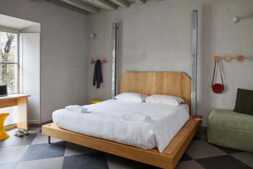 米兰Combo Milano的一间卧室配有一张带白色床单和一张沙发的床。