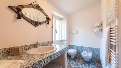 CatignanoLA CASA NEI VIGNETI 10, Emma Villas的一间带水槽、卫生间和镜子的浴室