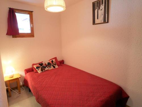 博福特Appartement Arêches-Beaufort, 2 pièces, 6 personnes - FR-1-342-256的一间卧室配有红色的床和两个枕头