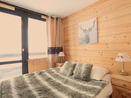葱仁谷Appartement Val Thorens, 3 pièces, 5 personnes - FR-1-637-3的卧室配有一张挂着鹿图的床铺。