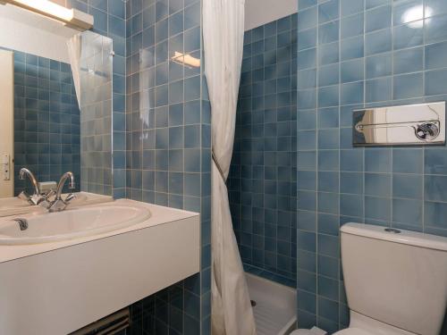 卡纳克Studio Carnac, 1 pièce, 4 personnes - FR-1-477-117的蓝色瓷砖浴室设有水槽和卫生间
