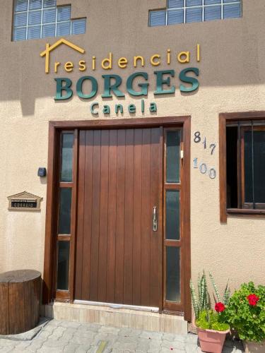 卡内拉RESIDENCIAL BORGES CANELA的一座带木门和标志的建筑