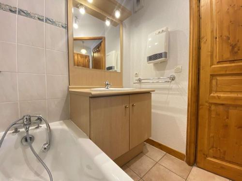 阿尔利河畔普拉兹Appartement Praz-sur-Arly, 2 pièces, 6 personnes - FR-1-603-10的带浴缸、水槽和镜子的浴室