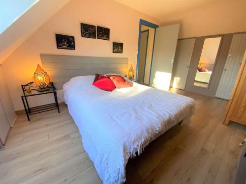PleuvenMaison Pleuven, 7 pièces, 7 personnes - FR-1-481-99的卧室配有白色的床和红色枕头