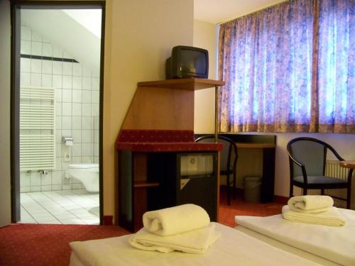 柏林柏林阿马德斯皇家酒店的客房设有两张床和带电视的浴室。