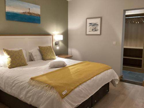 朗德斯通Quayside luxury apt Roundstoneselfcatering的一间卧室配有一张大床,床上有黄色的毯子
