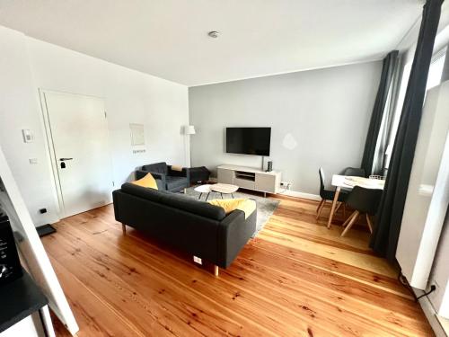 杜塞尔多夫Cityapartments Düsseldorf - Stresemannstraße的客厅配有黑色沙发和电视