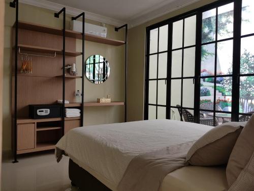 巴淡岛中心Danka@tudor residence的一间卧室设有一张大床和大窗户