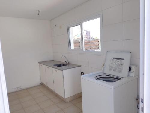 门多萨Oasis 1.6的小厨房配有洗衣机和水槽