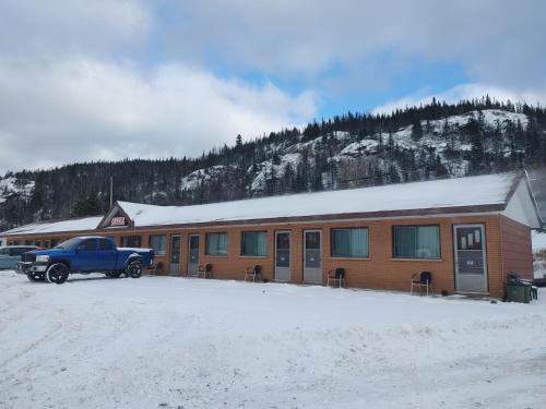 SchreiberSunset Motel的停在雪地中建筑物前面的卡车