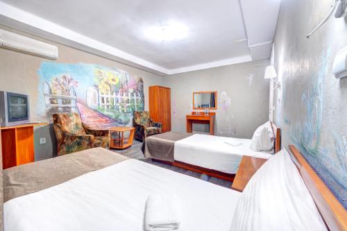 基辅豪罗斯维斯基酒店的酒店客房设有两张床,墙上挂有绘画作品