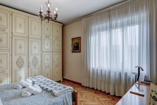都灵Bramante House - Intero Trilocale vicino alla Metro的一间卧室设有一张床和一个大窗户