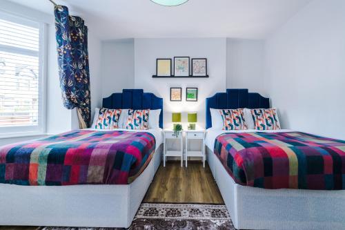 考文垂Beechwood Lodge Serviced Apartment的一间卧室设有两张床和窗户。