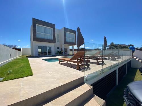 南蒂包PIPA Magnifique villa moderne en front de mer的一座带游泳池和两个长椅的房子