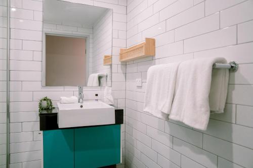 拜伦湾Vali Byron的浴室配有盥洗盆、镜子和毛巾