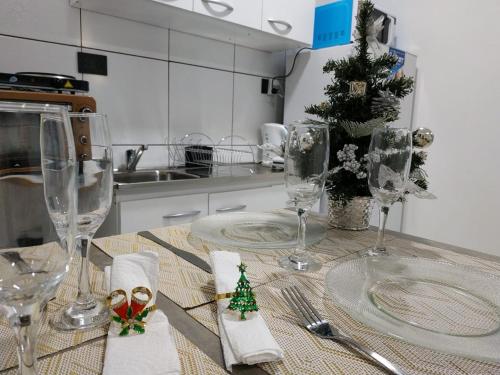 伊瓜苏港Tres Fronteras Apart 1的厨房配有带酒杯和圣诞装饰的桌子