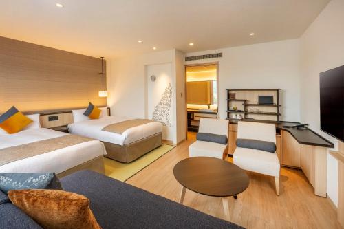 青梅市KAMENOI HOTEL Ome的酒店客房,设有两张床和一张沙发