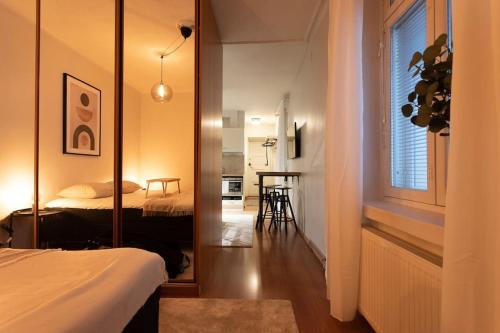 赫尔辛基Huoneisto Helsingin sydämmessä的带镜子的房间和一间带床的卧室