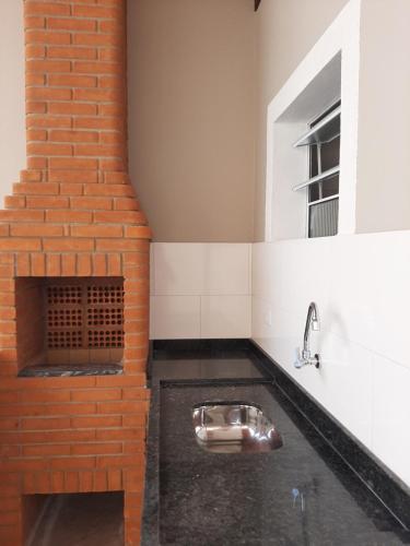 蒙加瓜Bela Mar Mongaguá的厨房设有水槽和砖墙