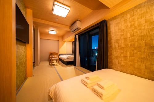 大阪WELLSTAY Shinsekai Wakyo的一间卧室配有带3条毛巾的床