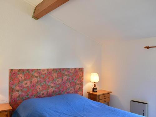 圣艾格夫Appartement Saint-Aygulf, 2 pièces, 4 personnes - FR-1-226A-14的一间卧室配有蓝色的床和花卉床头板