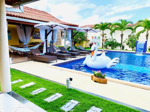 普拉杜Villa Paradise in Brazil - Praia de Guaratiba Prado-BA的一座房子中间带天鹅的游泳池