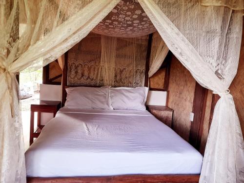 爱妮岛Erlittop Garden Eco Lodge的帐篷内一间卧室,配有一张床