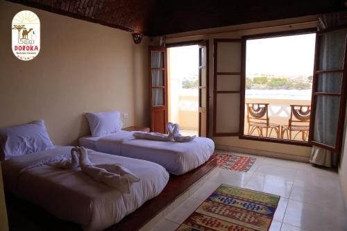 ShellalDoroKa Nubian House的客房设有两张床和一个美景窗户。