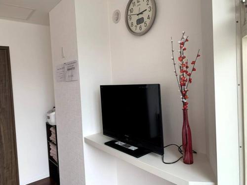 小樽Zenibako House 2f的架子上的电视,带花瓶和时钟