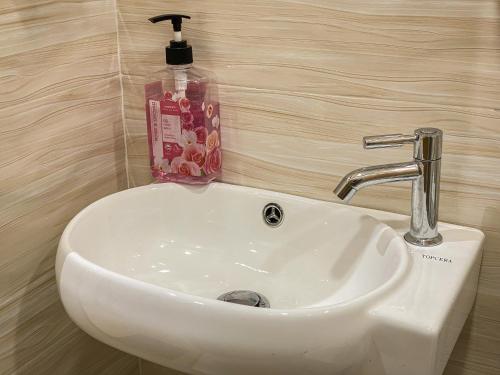 马德望Muni Residence & Spa的浴室内的白色水槽和一瓶肥皂