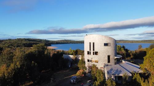 卡斯特鲁Lodge Parque Tepuhueico的享有湖畔白色大建筑的空中景色
