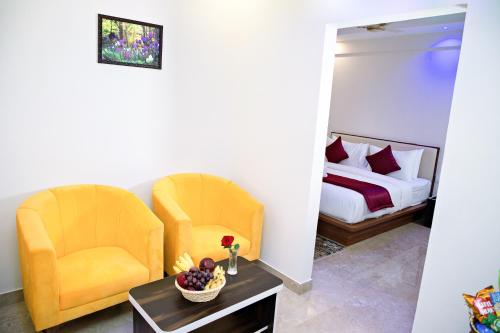 班加罗尔Villa Grand Hotel Near Kempegowda International Airport的配有2把椅子和一张桌子的房间