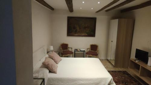 威尼斯Residence Castello Venezia的卧室配有白色的床和电视